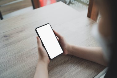 Asyalı kadın cep telefonu mesajı ya da mesajı tutuyor. İş kadını web 'e bakmak, e-kitap okumak, hisse senedi satmak için modern akıllı telefon kullanıyor.