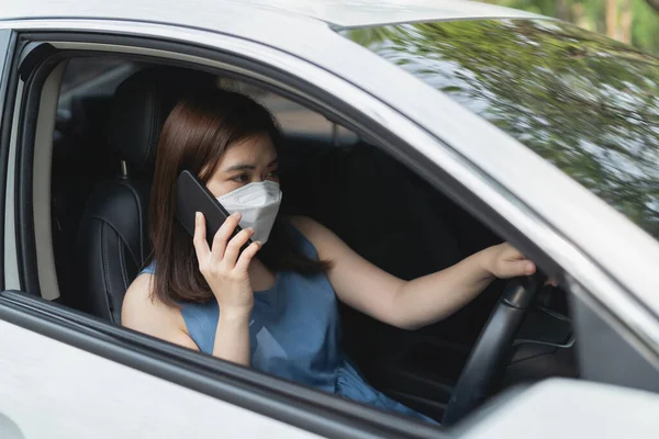 女性の運転中に携帯電話を使用しているアジアの女性は 車が故障したり事故が発生したときに保険や誰かを呼び出しています — ストック写真
