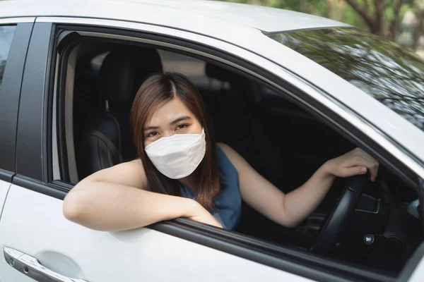 車を運転しながら外科用マスクをしたアジア系女性 車を運転して家を出るときにマスクをしていました — ストック写真