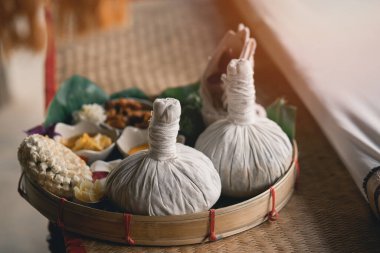 Spa massage wellness decorations setting on wood table. Thai spa massage traditional compress for hot massage and spa relaxing treatment of office syndrome. Massage for health concept.