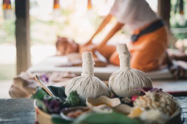 Spa massage wellness decorations setting on wood table. Thai spa massage traditional compress for hot massage and spa relaxing treatment of office syndrome. Massage for health concept.