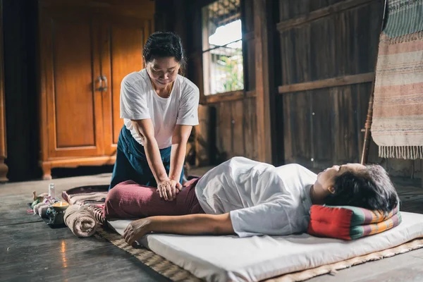 Massage and spa relaxing treatment of office syndrome traditional thai massage style. Asain senior female masseuse doing massage treat hand, back pain, arm pain, foot and stress for old woman tired.