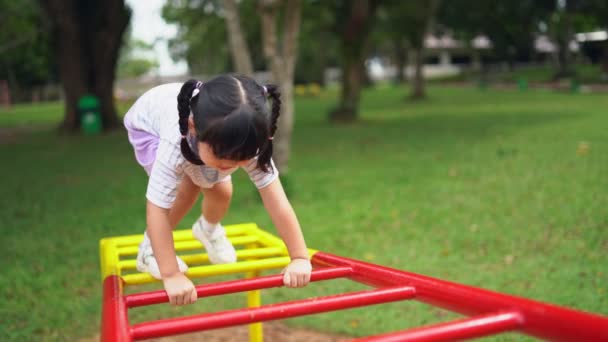 귀여운 아시아인 소녀는 학교나 유치원 놀이터에서 어린이들에게 운동장에서 등산하고 놀이터에서 — 비디오