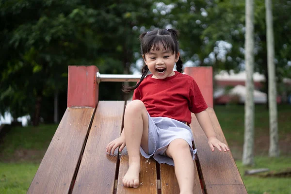 Okulda, anaokulunda ya da çocuk parkında oynayan tatlı Asyalı kız. Çocuklar için sağlıklı bir yaz aktivitesi. Küçük Asyalı kız çocuk parkında dışarı tırmanıyor. Çocuk dışarıda oyun oynuyor..