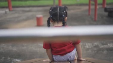 Okulda, anaokulunda ya da çocuk parkında oynayan tatlı Asyalı kız. Çocuklar için sağlıklı bir yaz aktivitesi. Küçük Asyalı kız çocuk parkında dışarı tırmanıyor. Çocuk dışarıda oyun oynuyor..
