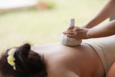 Massage spa relaxing treatment of office syndrome traditional thai massage style. Asian female massage traditional compress for hot massage back pain, arm pain and stress for woman tired from work.
