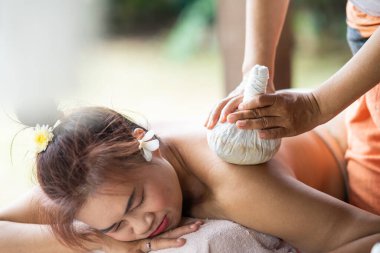 Massage spa relaxing treatment of office syndrome traditional thai massage style. Asian female massage traditional compress for hot massage back pain, arm pain and stress for woman tired from work.