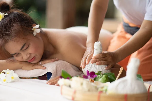 Massage spa relaxing treatment of office syndrome traditional thai massage style. Asian female massage traditional compress for hot massage back pain, arm pain and stress for woman tired from work.