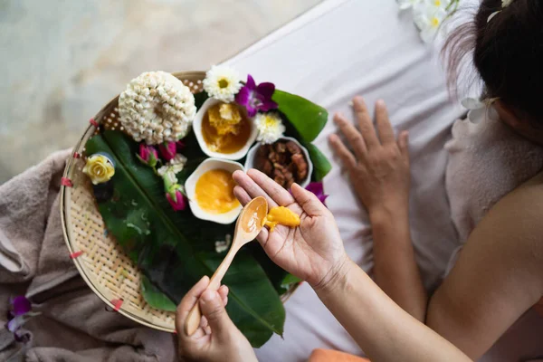 Hand of masseuse use honey for massage and spa relaxing treatment of office syndrome traditional thai massage style. Female masseuse doing massage scrup with salt treat back pain, arm pain and stress