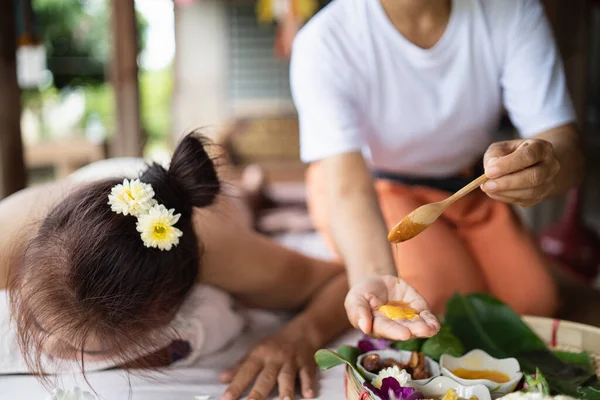 Hand of masseuse use honey for massage and spa relaxing treatment of office syndrome traditional thai massage style. Female masseuse doing massage scrup with salt treat back pain, arm pain and stress