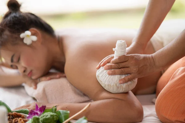 Massage spa relaxing treatment of office syndrome traditional thai massage style. Asian female massage traditional compress for hot massage back pain, arm pain and stress for woman tired from work.