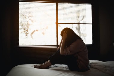sad woman suffering depression insomnia awake and sit alone on the bed in bedroom. sexual harassment and violence against women, health concept