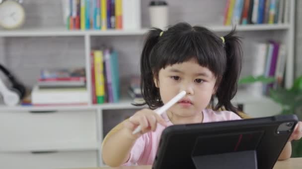 タブレット画面でデジタルペンとタッチオンスクリーンを使用してアジアの女の子が注意深く 刺激的な子供の概念です 画面時間が多すぎる 可愛いです女の子見るビデオ インターネット中毒の概念 — ストック動画