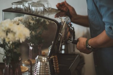 Barista Cafe restoranda kahve hazırlama servisi konsepti yapıyor. Kahve makinesiyle kafede taze kahve yapan el kahvecisini kapatın. Taze kahve espresso yapıyorum..