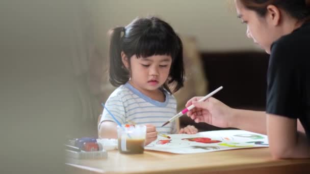 かわいいアジアの赤ちゃんの笑顔と水彩を使用してカラフルな塗料で彼女の母親の絵画 ペイントブラシの描画色を使用してアジアの女の子 ベビーアクティビティライフスタイルコンセプト — ストック動画