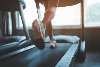 Ayaklarını kapat, spor koşucusu fitness kulübünde koşu bandında koşuyor. Kardiyo çalışması. Sağlıklı bir yaşam tarzı, spor salonunda antrenman yapan bir adam. Spor çalıştırma konsepti