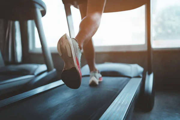 Close up of feet, sportman runner running on treadmill in fitness club. Cardio workout. Healthy lifestyle, guy training in gym. Sport running concept