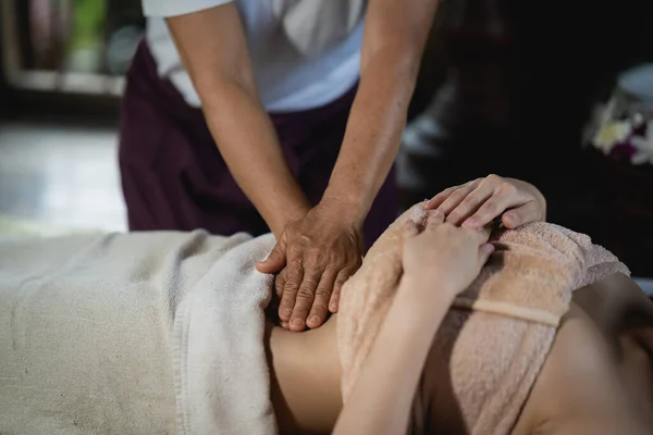 Abdominal massage and spa relaxing treatment of office syndrome traditional thai massage style. Asain female masseuse doing massage treat abdomen relax and stress for office woman tired from work.
