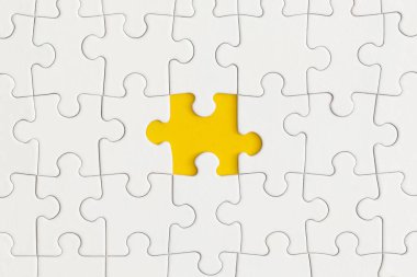 Sarı arka planda bulmacanın beyaz detayları. İş stratejisi, takım çalışması.