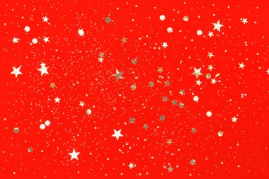 Kırmızı arka planda altın konfeti. Noel konsepti. Düz yatış, üst görünüm