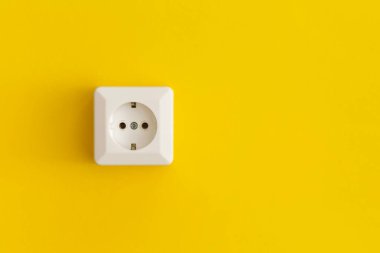 White plastic power socket on a yellow background