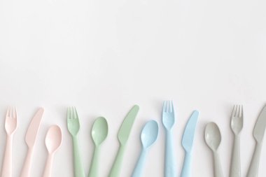Beyaz arka planda plastik çatal bıçak takımı. Plastik ve ekolojinin geri dönüşümü kavramı.