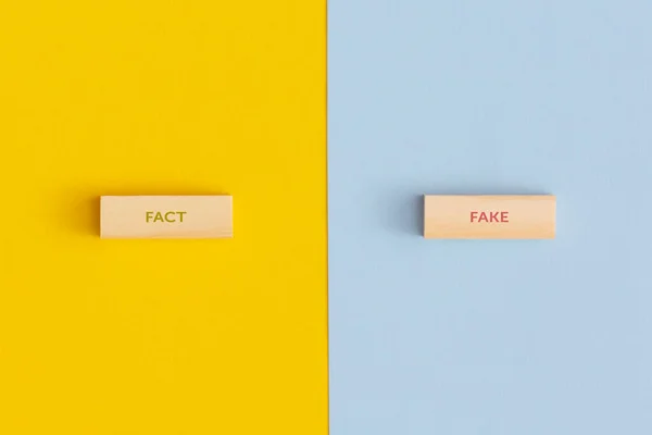 The words fact and fake on wooden blocks