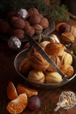 Ceviz, üzüm ve mandalina dilimli metal kasede ev yapımı fındık, yeni yıl tatili konsepti.