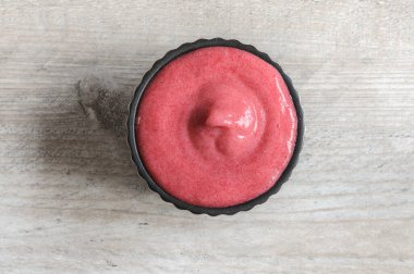 Gri ahşap bir masada ev yapımı meyve püresi. Köpüklü krema, sağlıklı bir tatlı. Düz yatış, seçici odak