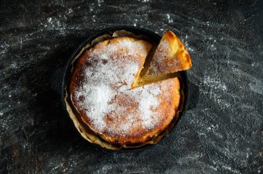 Üzerine pudra şekeri serpiştirilmiş ev yapımı kek serpiştirilmiş. Siyah arkaplan, seçici odak, doğal ışık