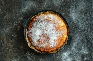 Toz şeker kaplı tavada ev yapımı turta. Siyah beton zemin, düz zemin