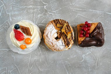 Gri mermer zemin üzerinde çeşitli hamur işlerinin satırı, kopya alanı ile üst görünüm