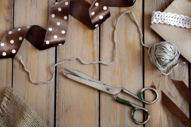 Puantiyeli kurdele, makas, ip, eski bir tahta masanın üzerinde. Seçici odak, üst görünüm