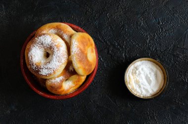 Pudra şekerli taze çörekler. Yukarıdan bak. Siyah arkaplan, seçici odak