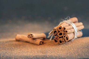 Kokulu tarçın çubukları bir demet yakın plan koyu bir arka planda Bokeh ile. Seçici odak, kopyalama alanı ile bulanık arkaplan. Doğal ışıklandırma