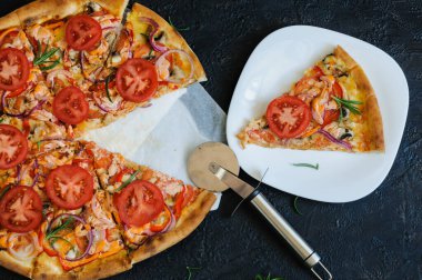 Biberiyeli ve domatesli vejetaryen pizza. Düz konum, üst görünüm, siyah arkaplan, seçici odak, doğal ışık