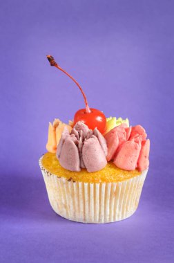 Kremalı kek ve leylak arkaplanlı kiraz. Seçici odak, doğal ışık