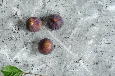 Gri arka planda taze incir meyveleri, üst manzara. Kopyalama alanı ile seçmeli odak