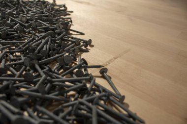 Köşedeki tahta masa çivileri, çelik çivileri arka plandaki stüdyo satışlarını inşaat malzemeleri atölyesi inşaatı zeminini gösteriyor.