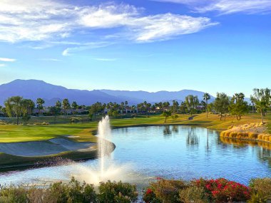 Palm Springs 'te yaz golf sahasında göl vahası lüks arka planda.