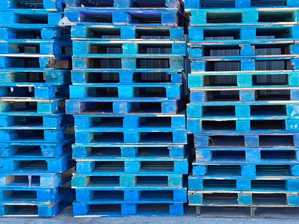 a pallet shipping receiving wood stacked palates trucking logistics wooden generic strong support rack warehouse painted blue cargo