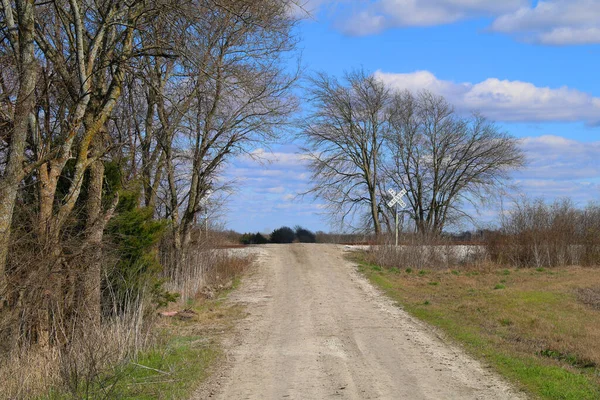 a single lane dirt country road lane rural countryside train tracks railroad crossing empty deserted driveway