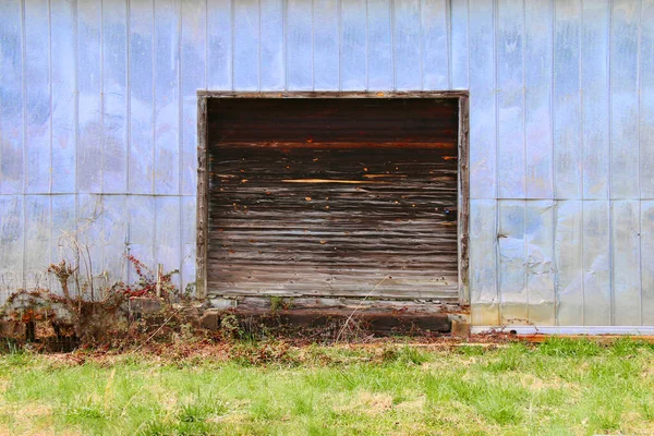 a steel metal barn warehouse farm building storage loading dock wooden door entrance