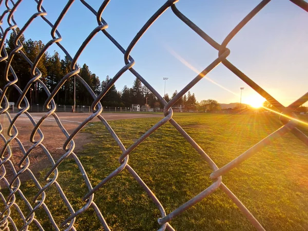 a sunset baseball field chain link fence closeup afternoon sports ballpark park sport fields athletics fencing