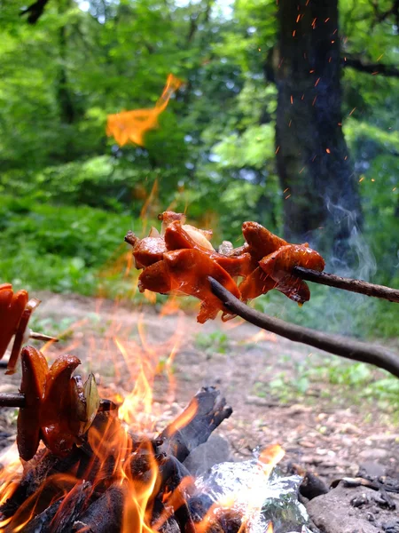 Salchichas asadas en llamas . Imagen de archivo