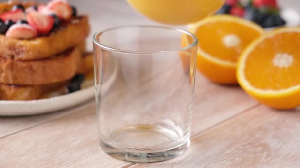 Sinaasappelsap Gieten Een Glas Houten Tafel Achtergrond Ontbijt Concept — Stockvideo