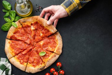 Siyah taş zemin üzerinde pepperoni pizza dilimi, tasarım elemanları, metin veya adresler için üst görünüm kopyalama alanı