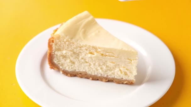 将焦糖酱汁倒入经典的纽约芝士蛋糕片 黄色背景 — 图库视频影像