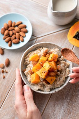 Kesilmiş papaya, badem ve chia tohumlu yulaf ezmesi.
