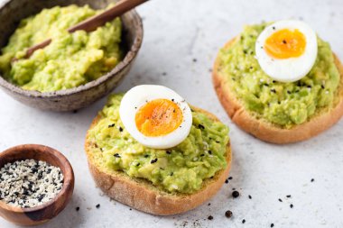 Kızarmış ekmeğin üstünde haşlanmış yumurta ve avokado.